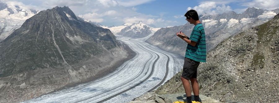 9 of 9, Student taking notes with view of glacier